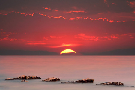 Vivid and dramatic red sky at the sunset over the sea.の写真素材