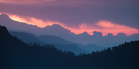 Panoramic Himalayan hills and mountains topped with a colorful dramatic sky.の写真素材