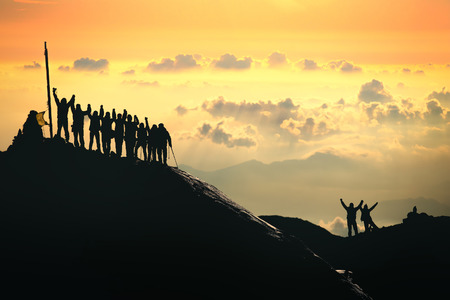 A group of people are standing on the top of the mountain.