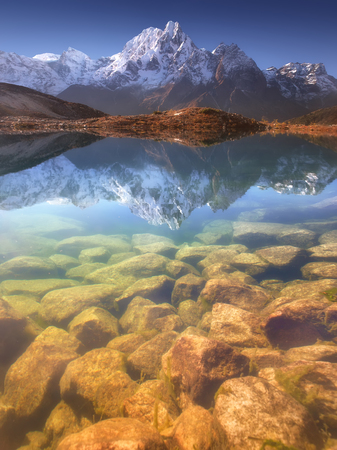 Nepal, Manaslu Region, a reflection in the Bimtang lake (3,680 m) of the Phungi peak (6,538 m) in the centre and the Mansiri Himal (7,059 m) at the left side.の写真素材