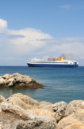 Ferry between Greek islands with rocks in foregroundの写真素材