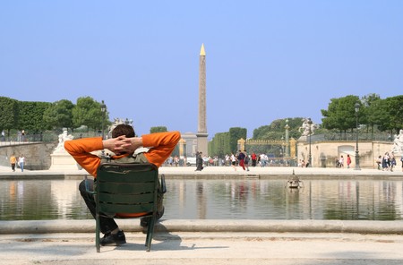 Paris. Man sitting in the Garden of the Tuilleries, looking at the obelisk on the Place de la Concordeの写真素材