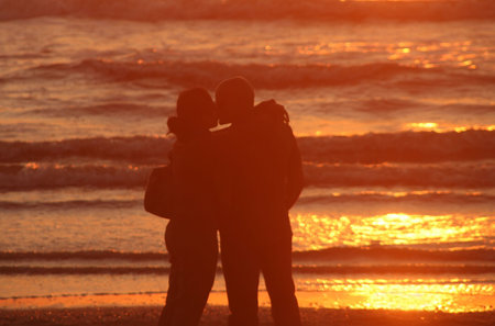 Kissing couple on the beach at sunsetの写真素材