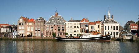 Dutch town of Maassluis, with houses and old steamboat in the old harborの写真素材