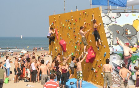 SCHEVENINGEN, HOLLAND - AUGUST 30, 2008: Annual Bouldering Competition on Scheveningen beach. Participants climbing artificial rock face.のeditorial素材