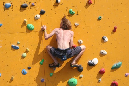 SCHEVENINGEN, HOLLAND - AUGUST 30, 2008: Annual Bouldering Competition on Scheveningen beach. Participant climbing artificial rock face.のeditorial素材