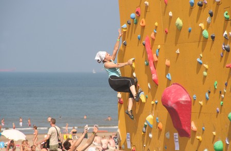 SCHEVENINGEN, HOLLAND - AUGUST 30, 2008: Annual Bouldering Competition on Scheveningen beach. Participants climbing artificial rock face.のeditorial素材