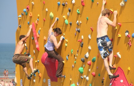 SCHEVENINGEN, HOLLAND - AUGUST 30, 2008: Annual Bouldering Competition on Scheveningen beach. Participants climbing artificial rock face.のeditorial素材
