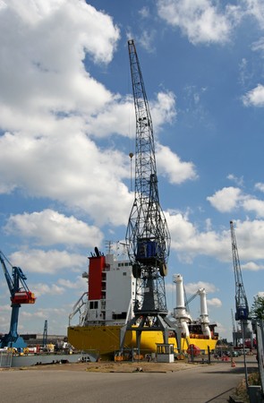 Shipyard with ship and large cranes in Rotterdam harborの写真素材
