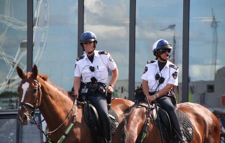 AMSTERDAM, AUGUST 19, 2010: Female police officers on horseback watch the crowd at Sail 2010 in Amsterdam, Holland on august 19, 2010のeditorial素材