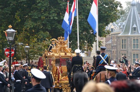 THE HAGUE, HOLLAND - SEPTEMBER 21, 2010: Golden Coach with Queen Beatrix approaches Parliament on Prinsjesdag (annual presentation of Government Policy to Parliament by the Queen) in The Hague, Holland on september 21のeditorial素材