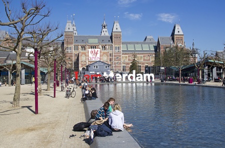 Amsterdam, Holland - April 8, 2011: People sitting on the edge of the pond in front of the recently renovated Rijksmuseum in Amsterdam, Hollandのeditorial素材