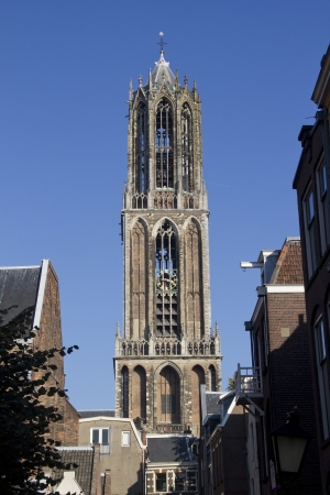 The tower of the Dom cathedral above a row of historical houses of Utrecht, Hollandの写真素材