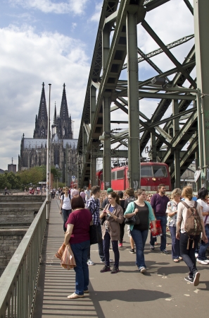 Cologne, Germany - August 27, 2013  Pedestrians on the footbridge and a train on the Hohenzollern bridge with the Cologne Cathedral in the background on August 27, 2013 in Cologne, Germanyのeditorial素材