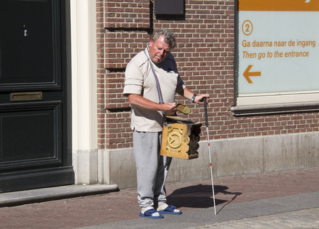 Amsterdam, Holland - August 1, 2013  Blind man with a musical organ on Dam square on August 1, 2013 in Amsterdam, Hollandのeditorial素材