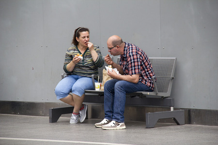 Cologne, Germany - August 30, 2013  Couple eating snacks while waiting for her train on a platform in the historic railway station of Cologne, Germany on August 30, 2013のeditorial素材