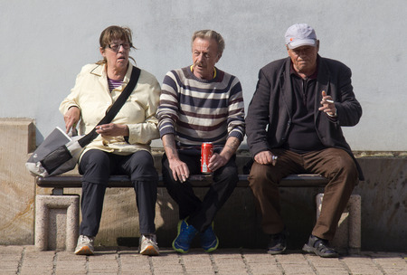 Speyer, Germany - May 2, 2014: Three homeless persons sit on a bench drinking coke and smoking in the old centre of Speyer, Germany on May 2, 2014のeditorial素材