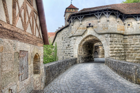 Medieval gate in the city wall, part of the old fortification of Rothenburg ob der Tauber, Germanyのeditorial素材