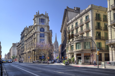 Barcelona, Spain - May 27, 2015: People and cars in a street lined with historical buildings in downtown Barcelona, on May 27, 2015 in Barcelona, Spainのeditorial素材