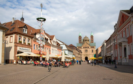 Speyer, Germany - May 2, 2014: Tourists sit in cafe and walk in the mainstreet of Speyer, flanked with historical buildings, shops and the old clocktower in the old centre of Speyer, Germany on May 2, 2014のeditorial素材