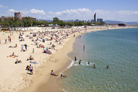 Barcelona, Spain - May 23, 2015: People on the beach and swimming in Barcelona, Spain on May 23, 2015.のeditorial素材