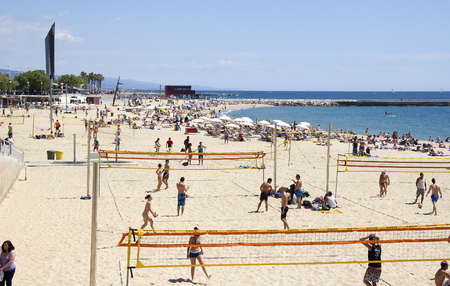 Barcelona, Spain - May 23, 2015: People play volleyball on the beach in Barcelona, Spain on May 23, 2015.のeditorial素材