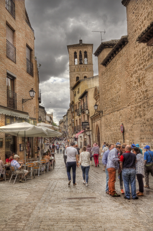 Toledo, Spain - May 28, 2016: Tourists walk in the Calle de Santo Tome with the tower of the Santo Tom  church in Toledo, Spain on May 28, 2016のeditorial素材