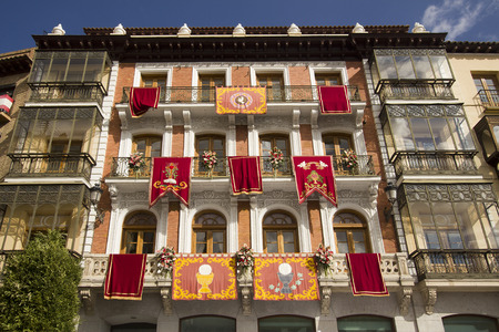 Banners with historical emblems hang from windows of an old building in the Plaza de Zocodover in Toledo, Spainのeditorial素材