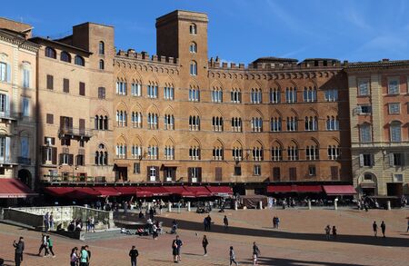 Siena, Italy - September 26, 2017: Tourists walking on the Piazza del Campo town square surrounded by historical buildings in Siena, Italy on September 26, 2017のeditorial素材