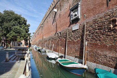Canal with boats and walls of the arsenal of Venice, Italyのeditorial素材