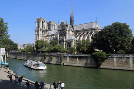 Paris, France - May 19, 2018: Tour boat, tourists and Notre Dame cathedral in Paris, France on May 19, 2018のeditorial素材