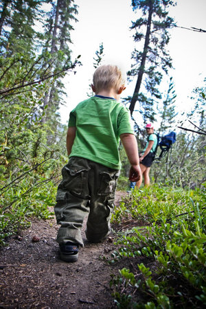 Boys hiking on trail with mom