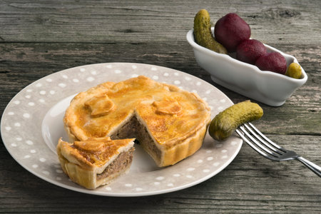 Traditional British pork pie with lard crust, gherkins and pickled red beet.