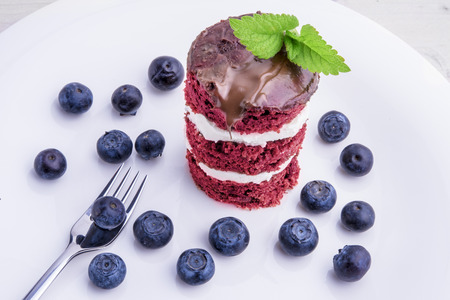 Red velvet cake with blueberries. US flag themed dessert, ideal for Independence day.
US flag themed dessert, ideal for Independence day. Cake is iced with chocolate and decorated with balm mint, Melissa, leaves.の写真素材