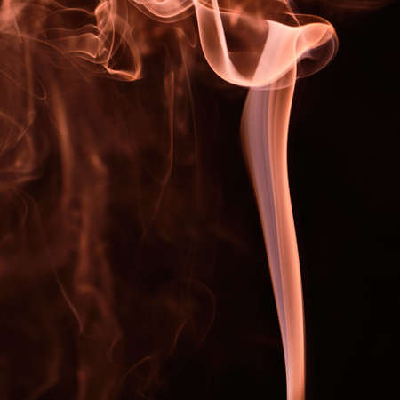Orange waterfall smoke abstraction on black backgroundの写真素材