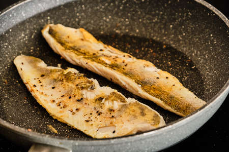 Cooking tasty zander fillets on frying panの写真素材