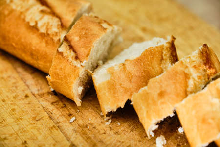 Tasty baquette cut on wooden cutting board close up detailの写真素材