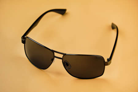 Modern sunglasses isolated on yellow sand color backgroundの写真素材