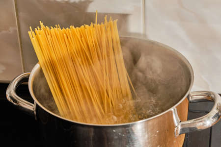 Tasty spaghetti in metal cooking pot with boiling waterの写真素材