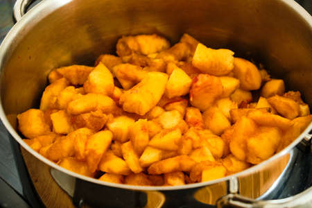 Pieces of peach fruit in cooking pot preparing homemade marmaladeの写真素材