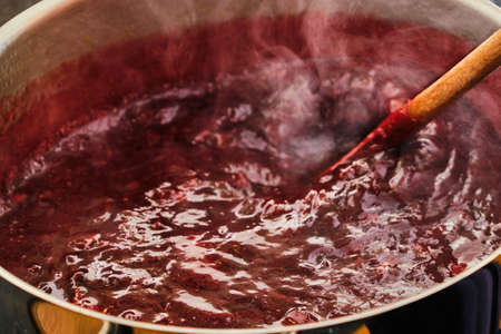 Stiring boiling plum fruit preparing tasty homemade marmalade close up detailの写真素材