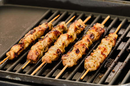 Cooking tasty pork meat souvlaki on hot electric grillの写真素材