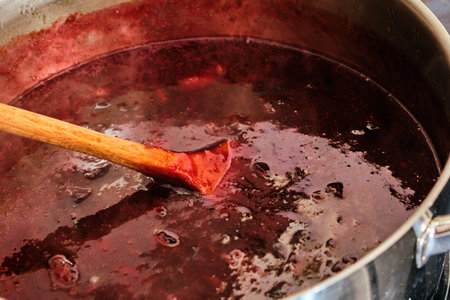 Preparing homemade, tasty and fresh plum fruit marmalade in metal cooking pot