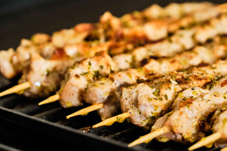 Cooking homemade tasty pork meat souvlaki spiced with oregano on grill, traditional greek foodの写真素材
