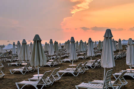 Sandy beach in Side, Turkey, with sun beds and umbrellas one beautiful evening few moments before sunset in summerの写真素材
