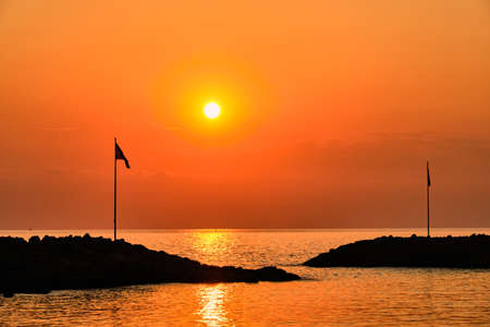 View on ship entrance silhouette to port in Side, Turkey, one evening sunset time in summerの写真素材