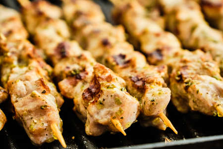 Cooking homemade tasty pork meat souvlaki spiced with oregano on grill, traditional greek foodの写真素材