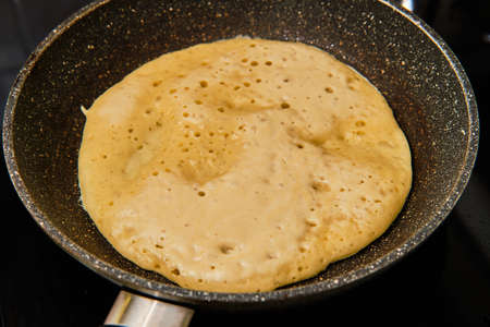 Cooking homemade tasty big pancake on frying pan on stoveの写真素材