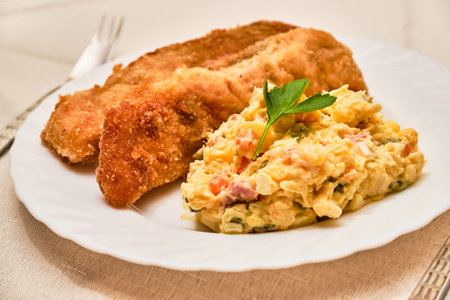 Tasty homemade fried carp fish with potato salad - carp and potato salad - on white plate on cloth with serving. Czech traditional christmas food.の写真素材