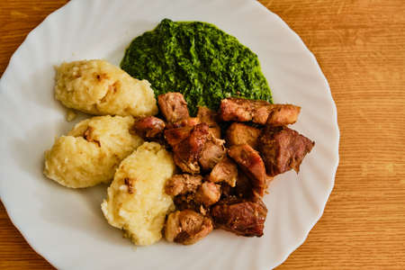 Tasty roasted pork meat pieces - pork baked - with czech furry dumplings - hairy dumplings - and spinachの写真素材